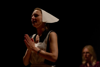 Michaela Allendorf mit weißer Schürze und Häubchen, Sabine Schremm im Hintergrund